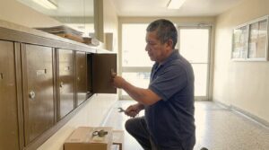 Locksmith Liberty technician replacing an apartment mailbox lock in a Miracle Mile, Los Angeles lobby